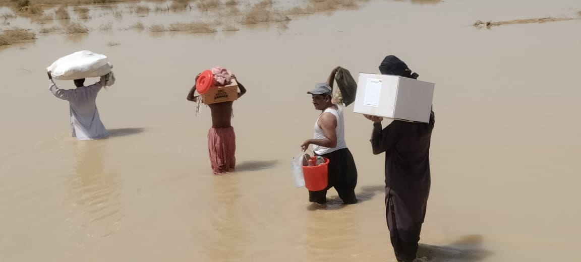 _801_https://www.helpage.org/silo/images/cdf-delivering-helpage-aid-wading-through-water-1_1152x520.jpg