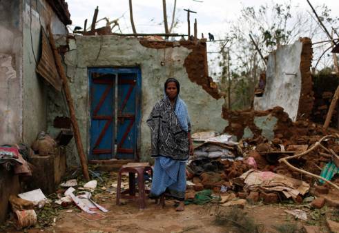  _212_https://www.helpage.org/silo/images/cyclone-phailin-a-woman-stands-outside-her-damaged-house-after-cyclone-phailin-hit-gopalpur-in-ganjam-district-_491x338.jpg