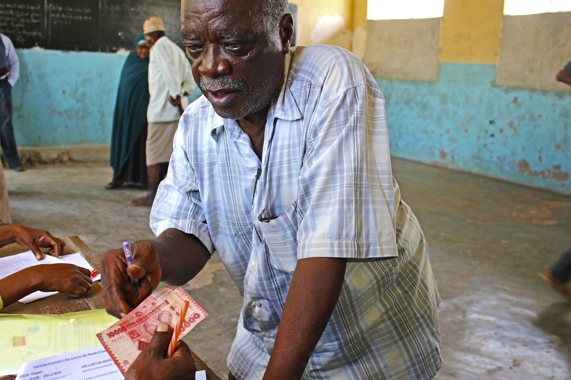  _519_https://www.helpage.org/silo/images/man-receives-pension-in-zanzibar_2000x1333.jpg