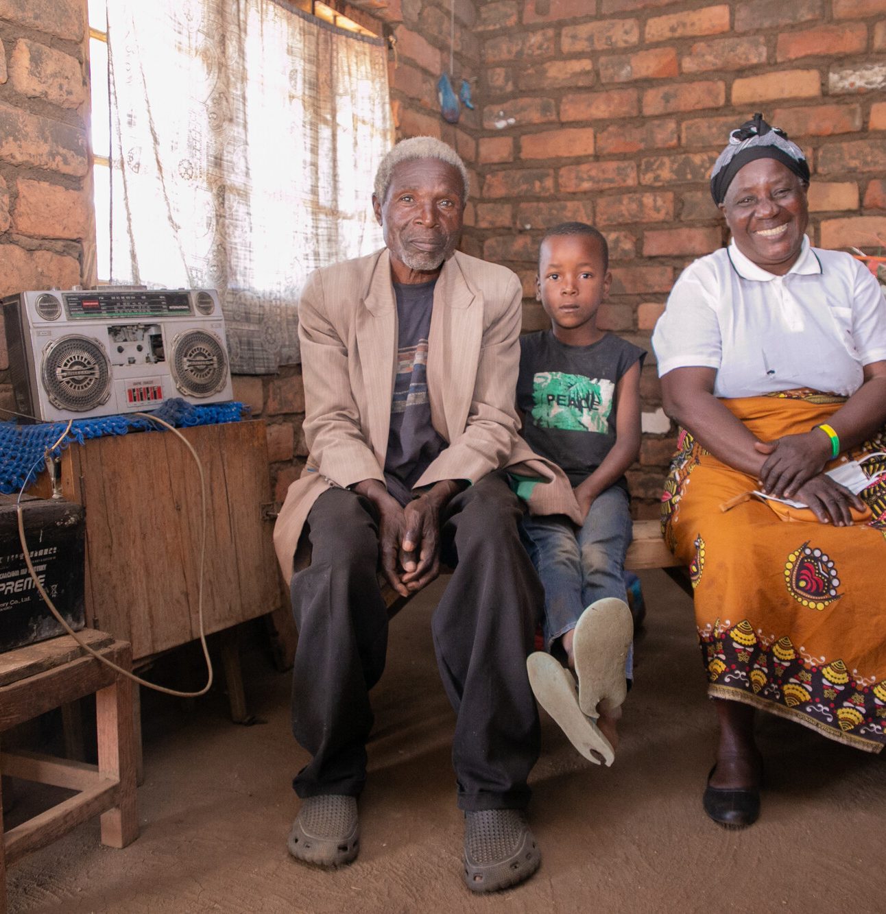 The story of Petros Yakobe Apparel, Clothing, Human, Person, Sitting, Wood The story of Petros Yakobe.He lives with his wife and 2 grandchildren...He belongs to Tiyanjane Club (Older Persons Association). ..The awareness of elderly people’s right by MANEPO from 2017 helped people like Petros Yakobe to benefit from projects taking place in their community through his participation. ..Before 2017 elderly people were never chosen or given any chance in any development activities. But after the awareness, the chief starting choosing elderly people first before the youth for any income generating activity. ..Mr Yakobe was involved in construction of drainage and at the end he was paid some money with which he bought solar panels for electrification of his house. ..This solar panel has made it possible for the family to charge their phones and also listen to the radio daily. ..“I am happy that as elderly people we are now being recognized in our communities and if it wasn’t for MANEPO to educate us on these rights I wouldn’t have been able to buy solar panels.”