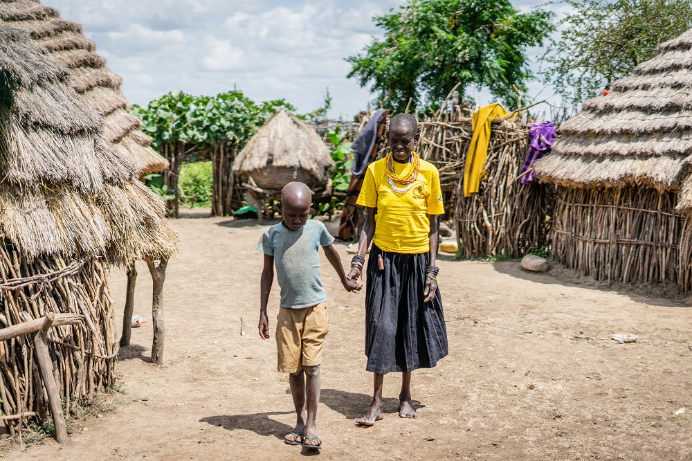  _800_https://www.helpage.org/silo/images/loucho-alice-is-led-around-her-yard-by-her-grandchild_1000x666.jpg