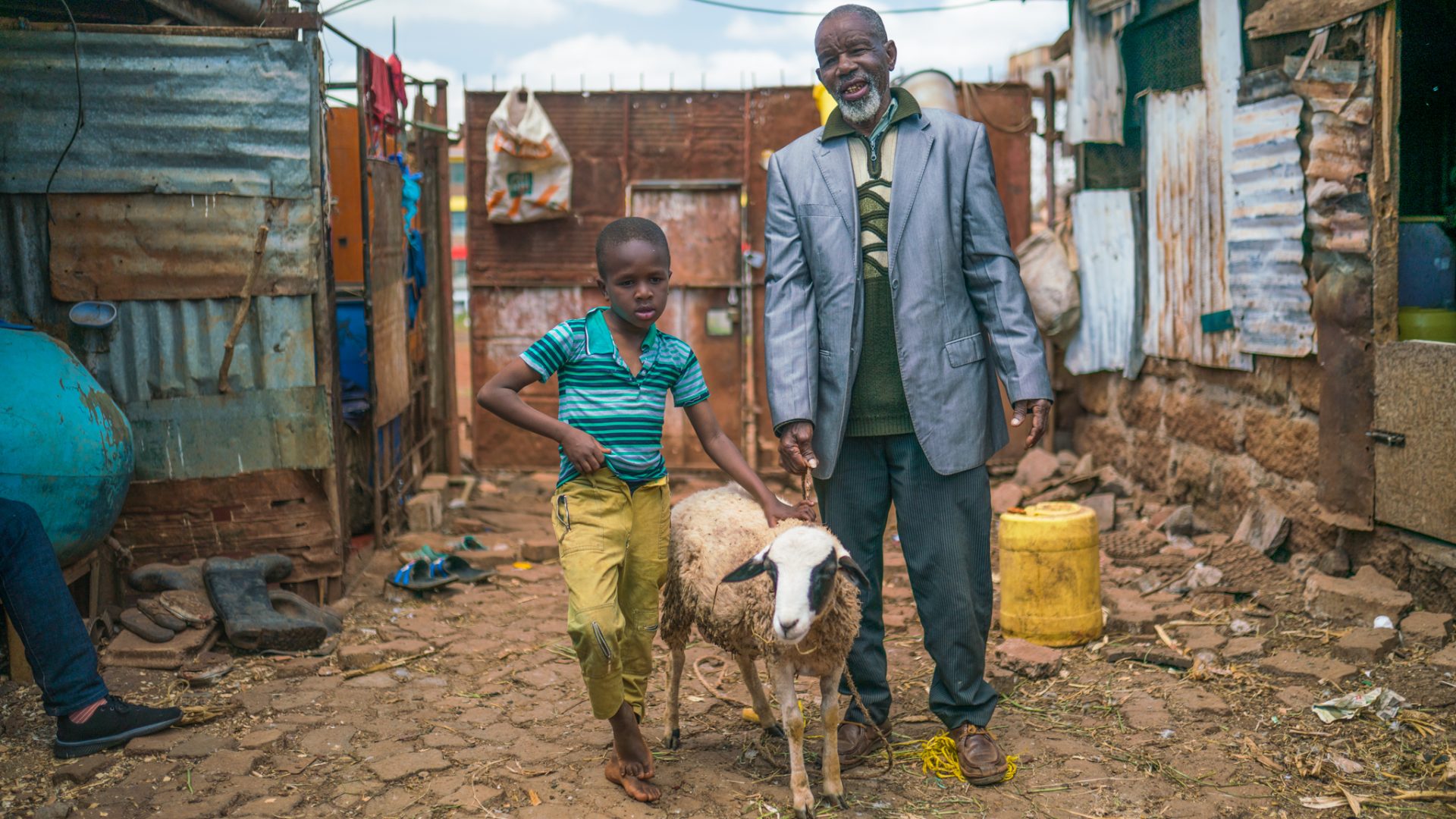 George poses with his son and one of his sheep